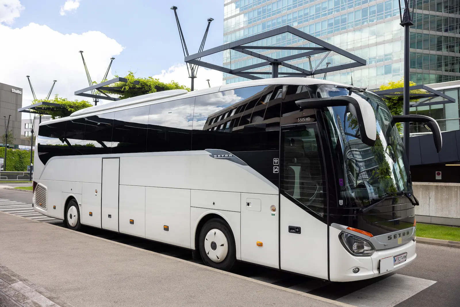 Ein eleganter Shuttle-Service-Wien-Van parkt vor einem modernen Flughafengebäude, bereit für luxuriöse Gästeanreisen.