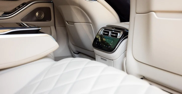 Der luxuriöse Innenraum eines MB S-Class Long Inside Rear mit cremefarbenen Ledersitzen und modernem Bedienfeld.