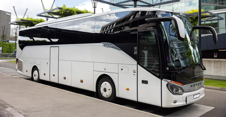 Der Setra Front View two zeigt einen eleganten weißen Luxusbus von vorne mit modernem Design, geparkt vor einem städtischen Hintergrund.
