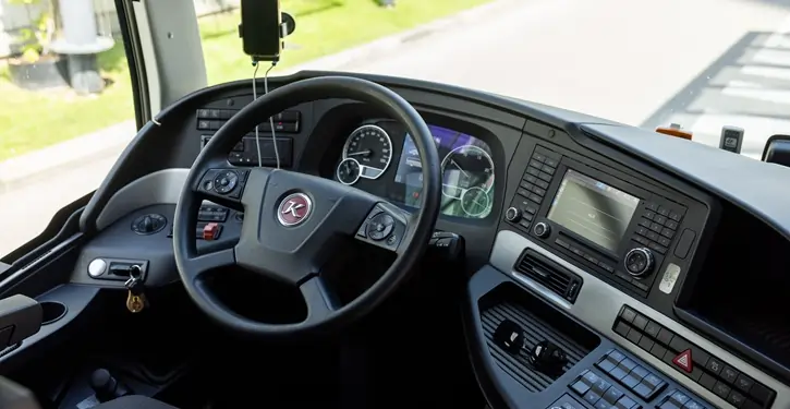Der Setra Inside Front View zeigt das moderne Cockpit eines Luxus-Busses mit Lenkrad, Armaturenbrett und digitalem Display im Innenraum.