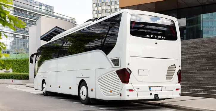 Der Setra Rear View zeigt einen stilvollen weißen Luxusbus von hinten, geparkt vor einem modernen städtischen Hintergrund.